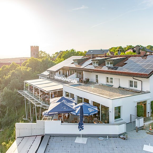 Die Ritterschänke von oben. Im Hintergrund liegt die Burg Randeck umgeben von Bäumen.